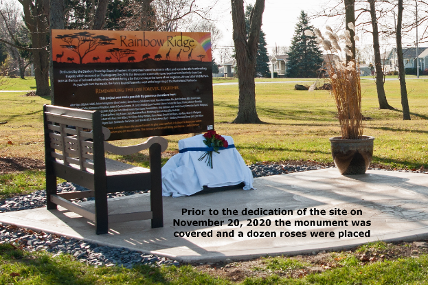 Park monument with bench and decorative flowers.