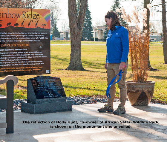 Woman unveiling monument at outdoor park.