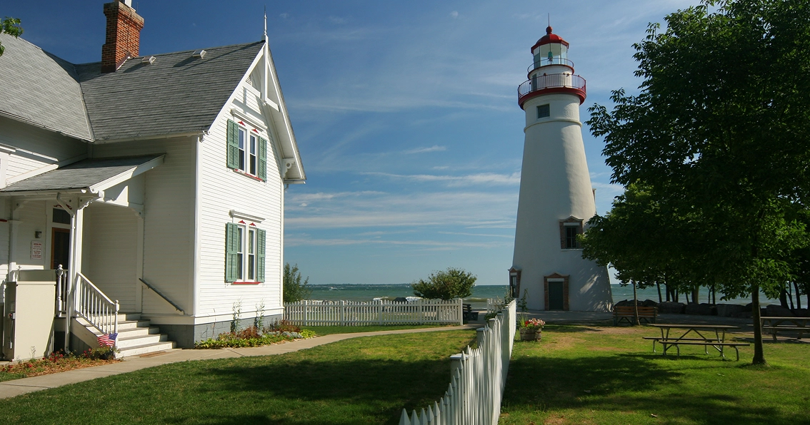 White house and lighthouse by the sea.