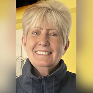 Smiling person with short, light blonde hair.