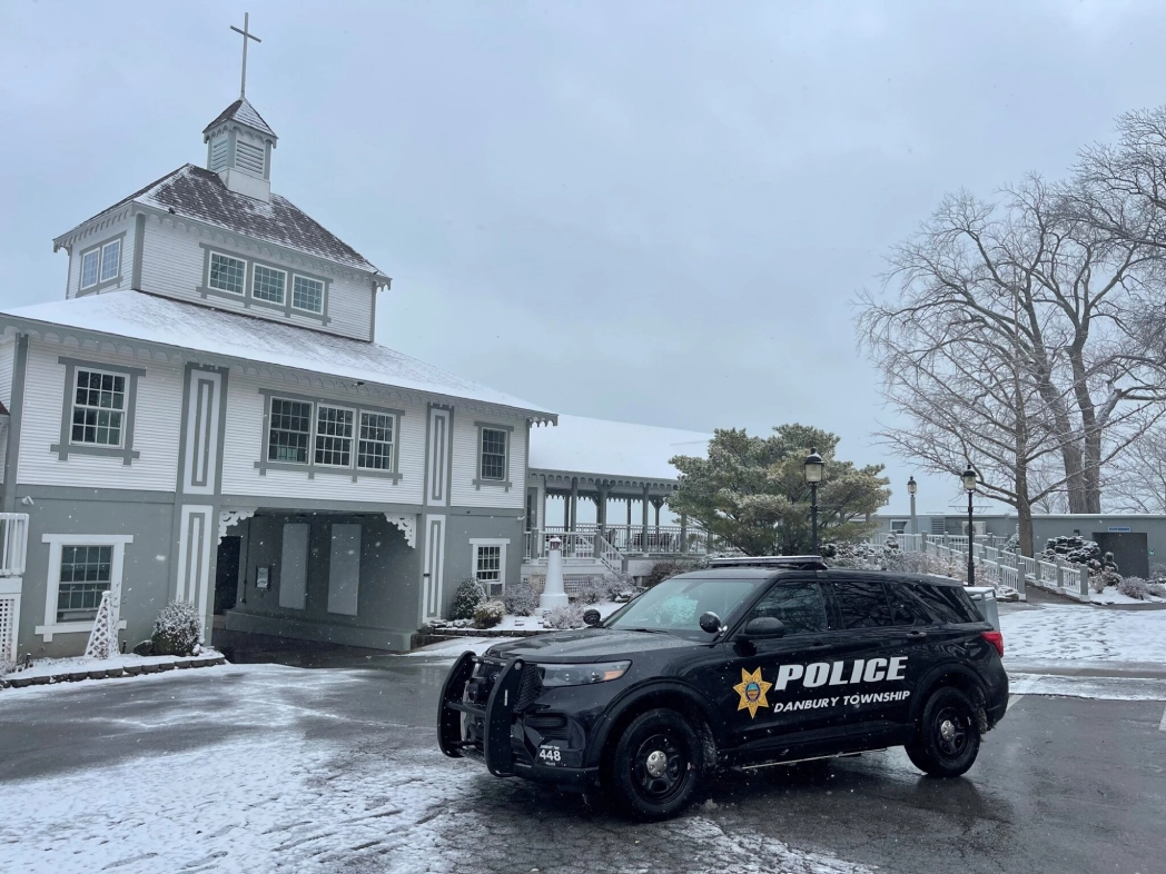 Police car parked near snowy building.